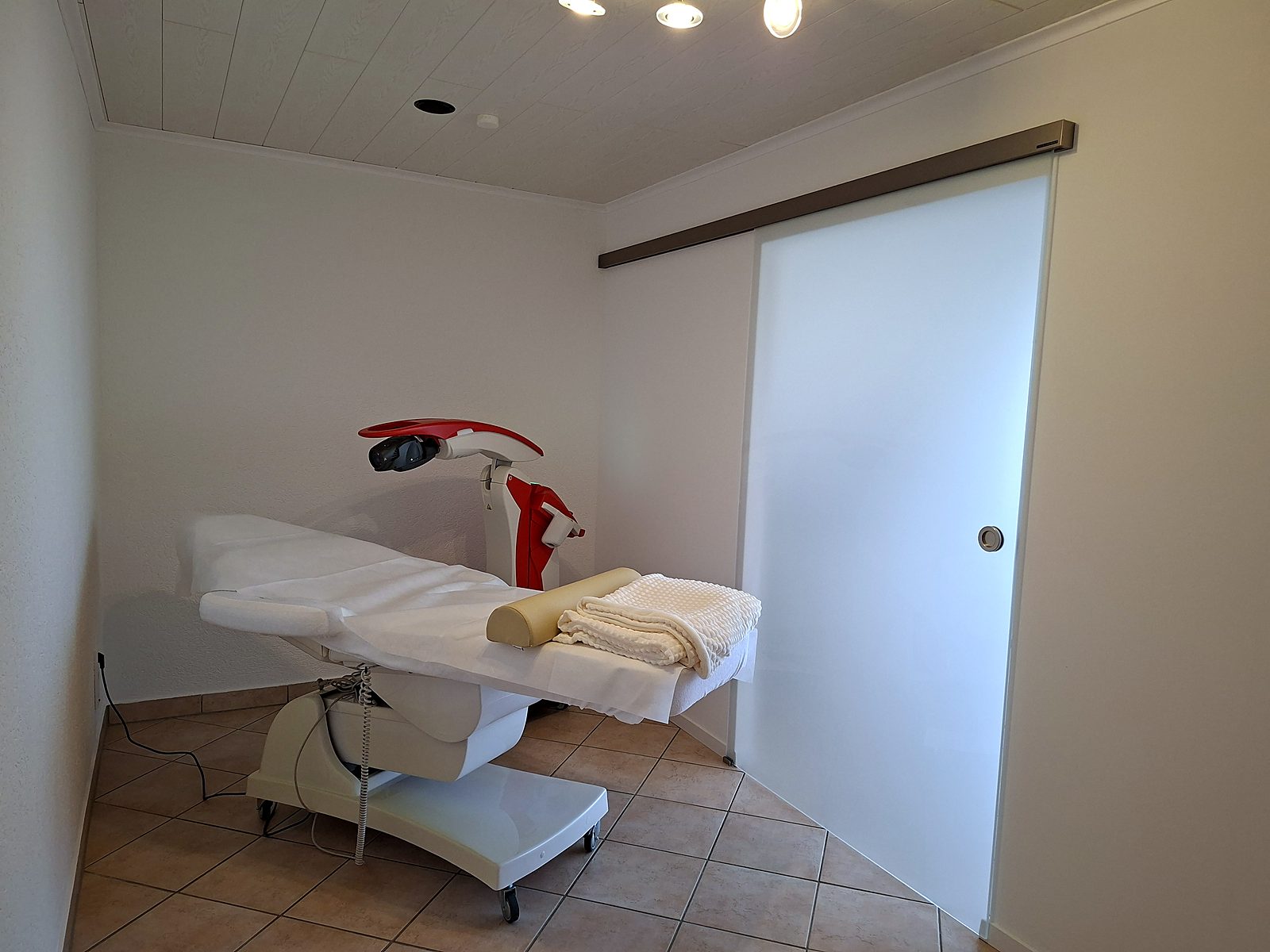 Behandlungsraum der Privatpraxis für Lasertherapie in Kirchardt-Bockschaft mit Therapieliege und Laserkopf